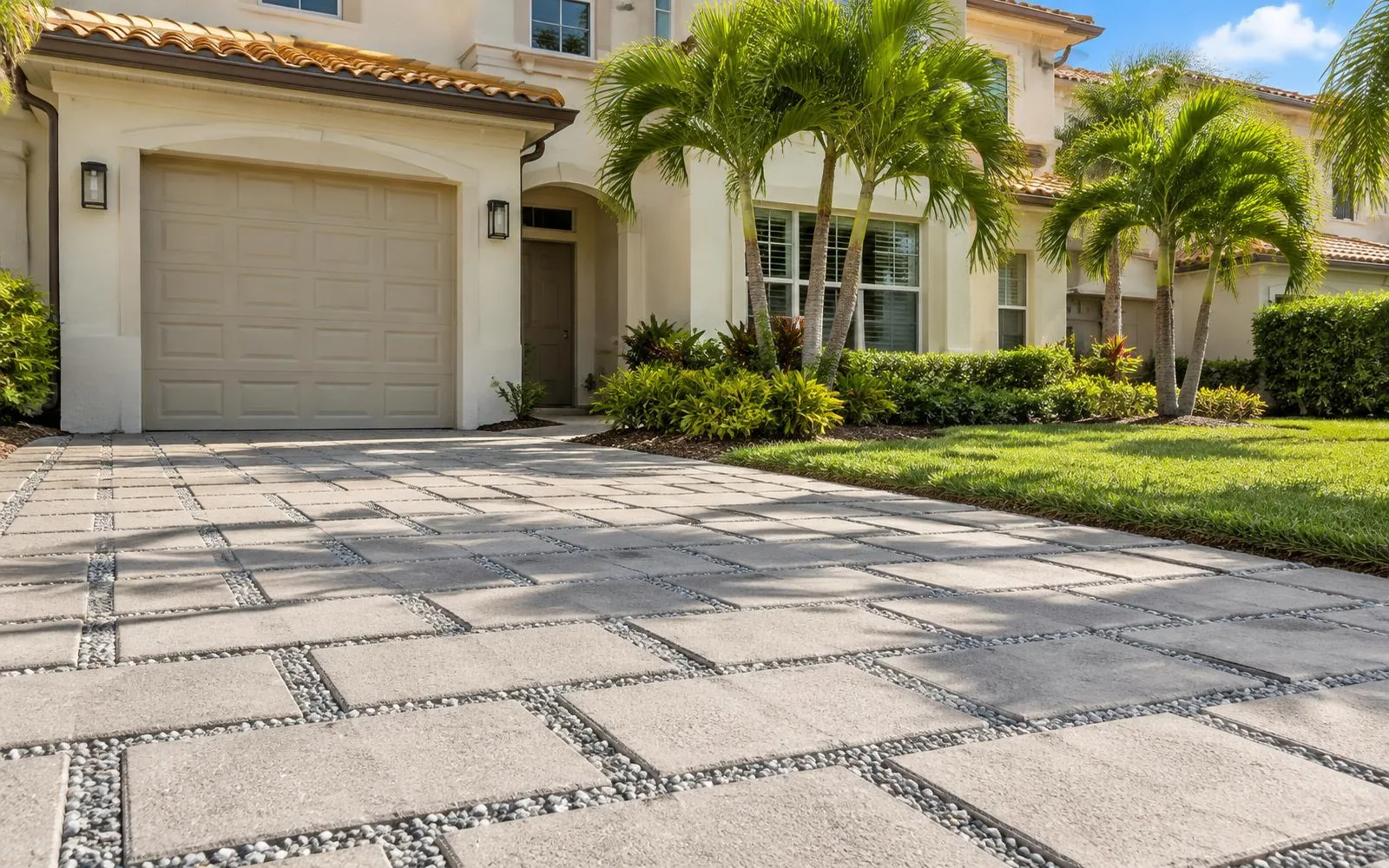 Permeable paver driveway with gravel-filled joints and grass beside villas in Pembroke Pines