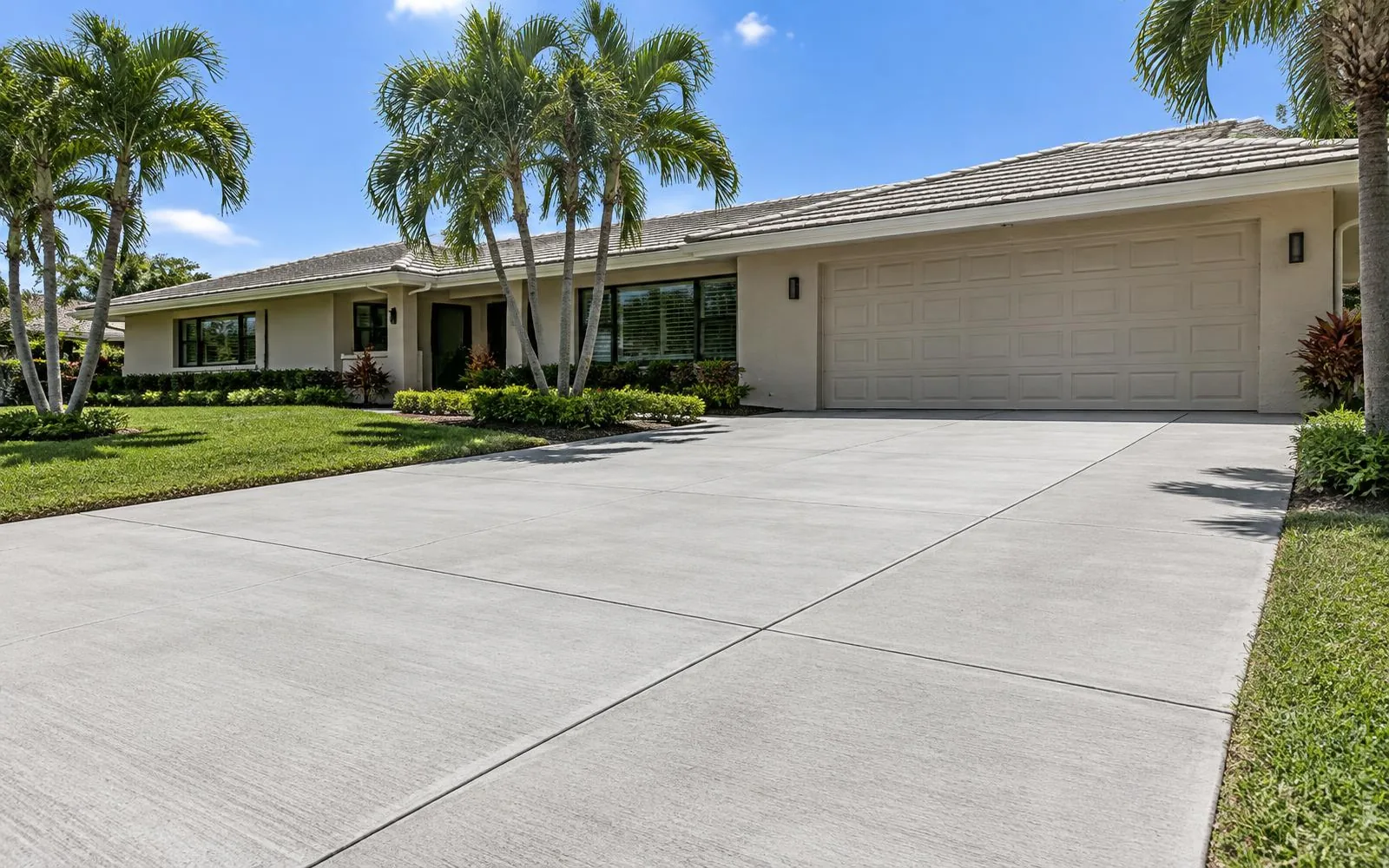 New broom-finish driveway with crisp control joints at a beige ranch home in Pembroke Pines